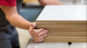 Man holding multiple mdf boards