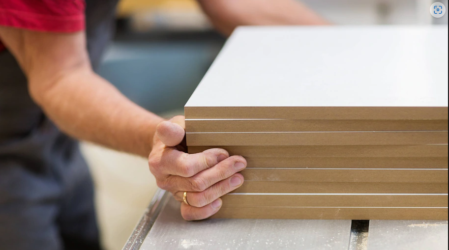 Man holding multiple mdf boards